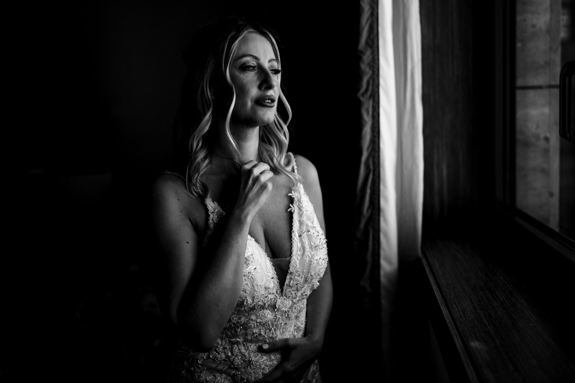 Ritratto in bianco e nero della sposa alla finestra alla Tenuta La Madonnina di Barni.