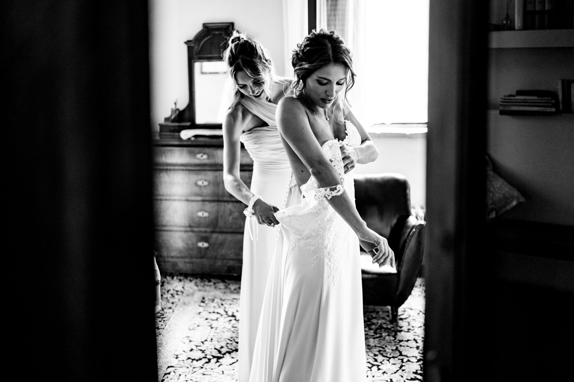 La sposa indossa il suo abito da matrimonio, un momento carico di emozione e aspettativa. Fotografia scattata da Paolo Lamperti Fotografo Matrimonio Varese al Castello di Tabiano.