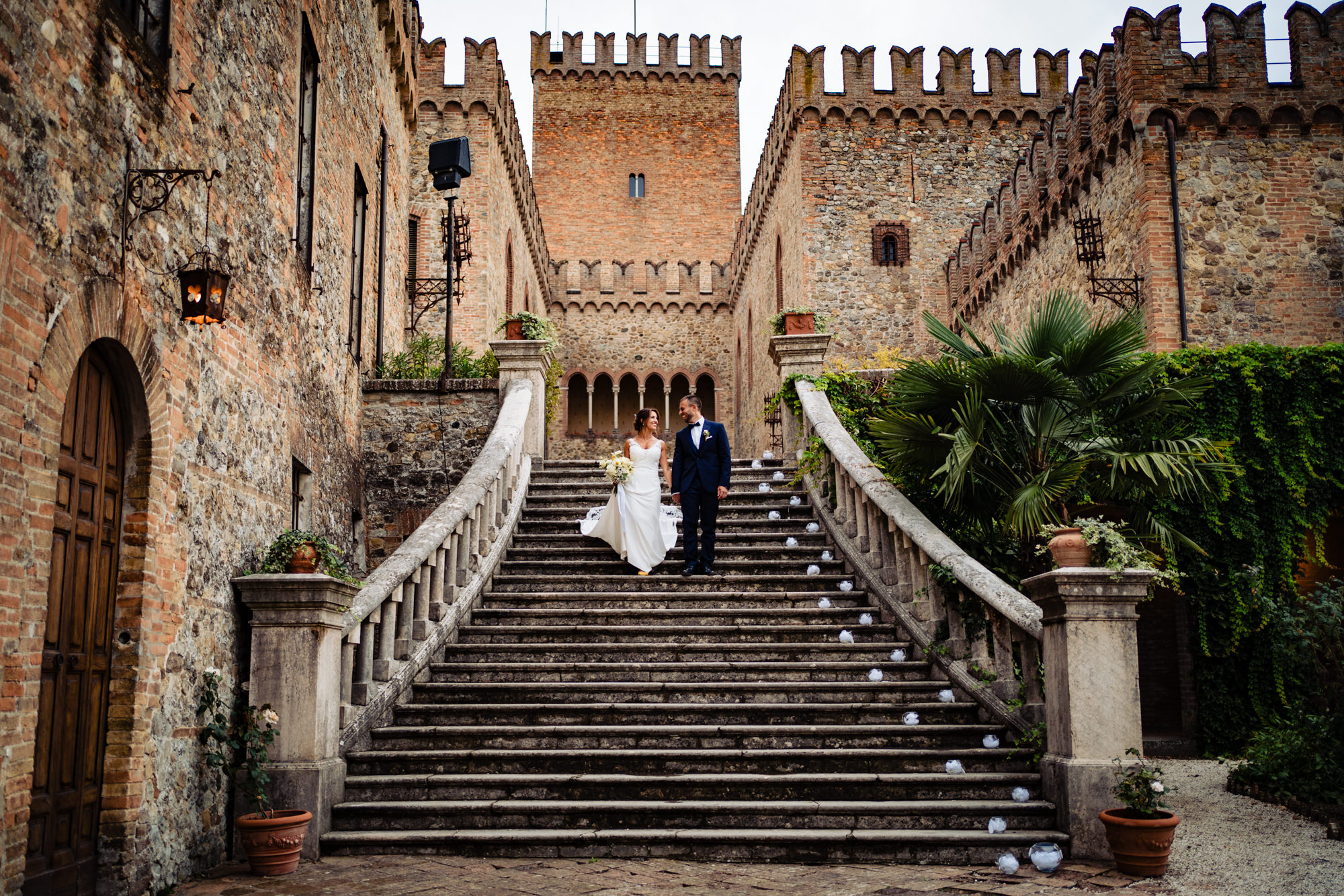 Roberta e Agustin scendono insieme dalla scalinata del Castello di Tabiano. Fotografia scattata da Paolo Lamperti Fotografo Matrimonio Varese al Castello di Tabiano.