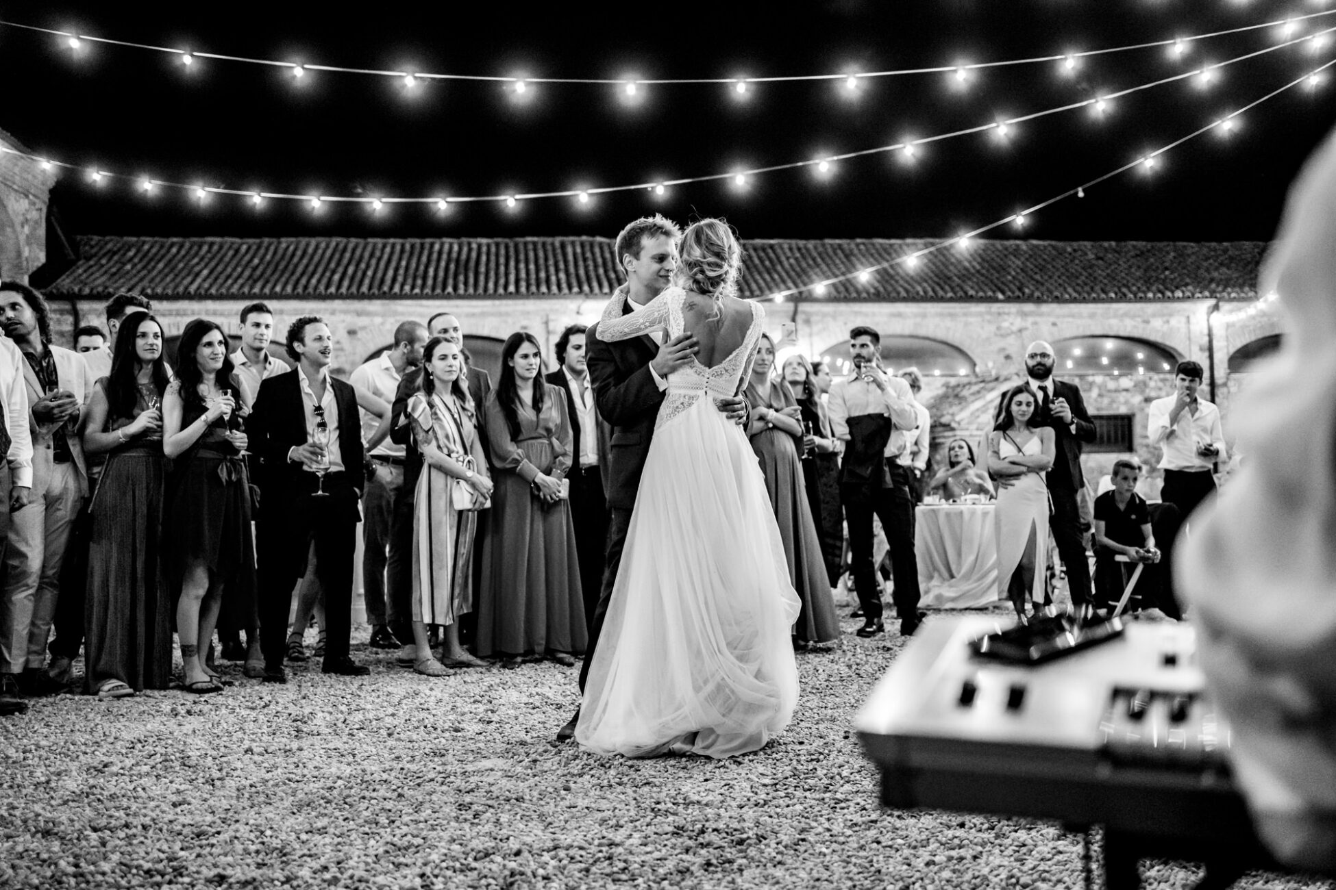 Gli sposi ballano sotto le lucine nel cortile del Borgo della Rocca, immersi in un’atmosfera romantica.