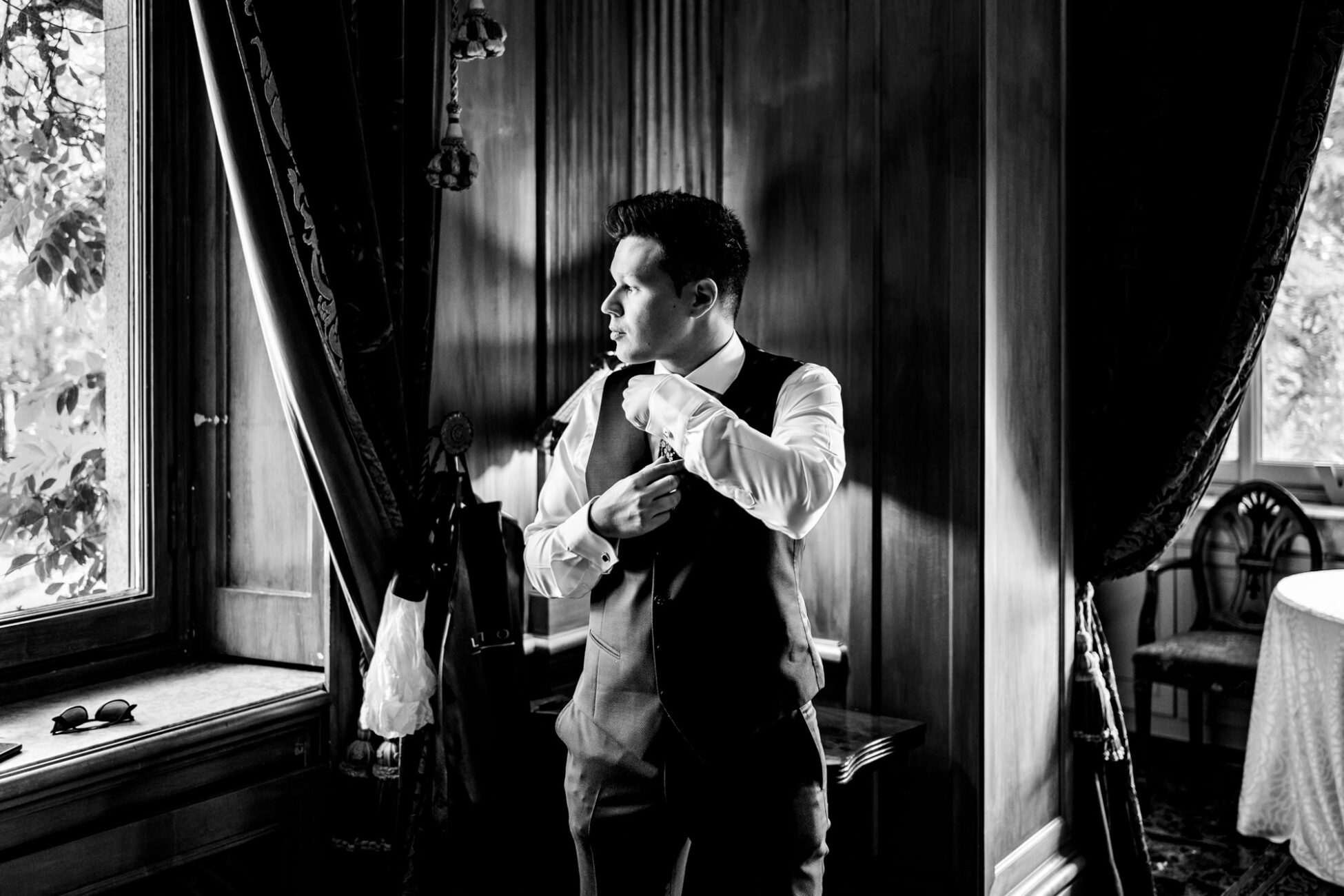 Ritratto in bianco e nero dello sposo che si aggiusta la cravatta - fotografo matrimonio villa paradeisos